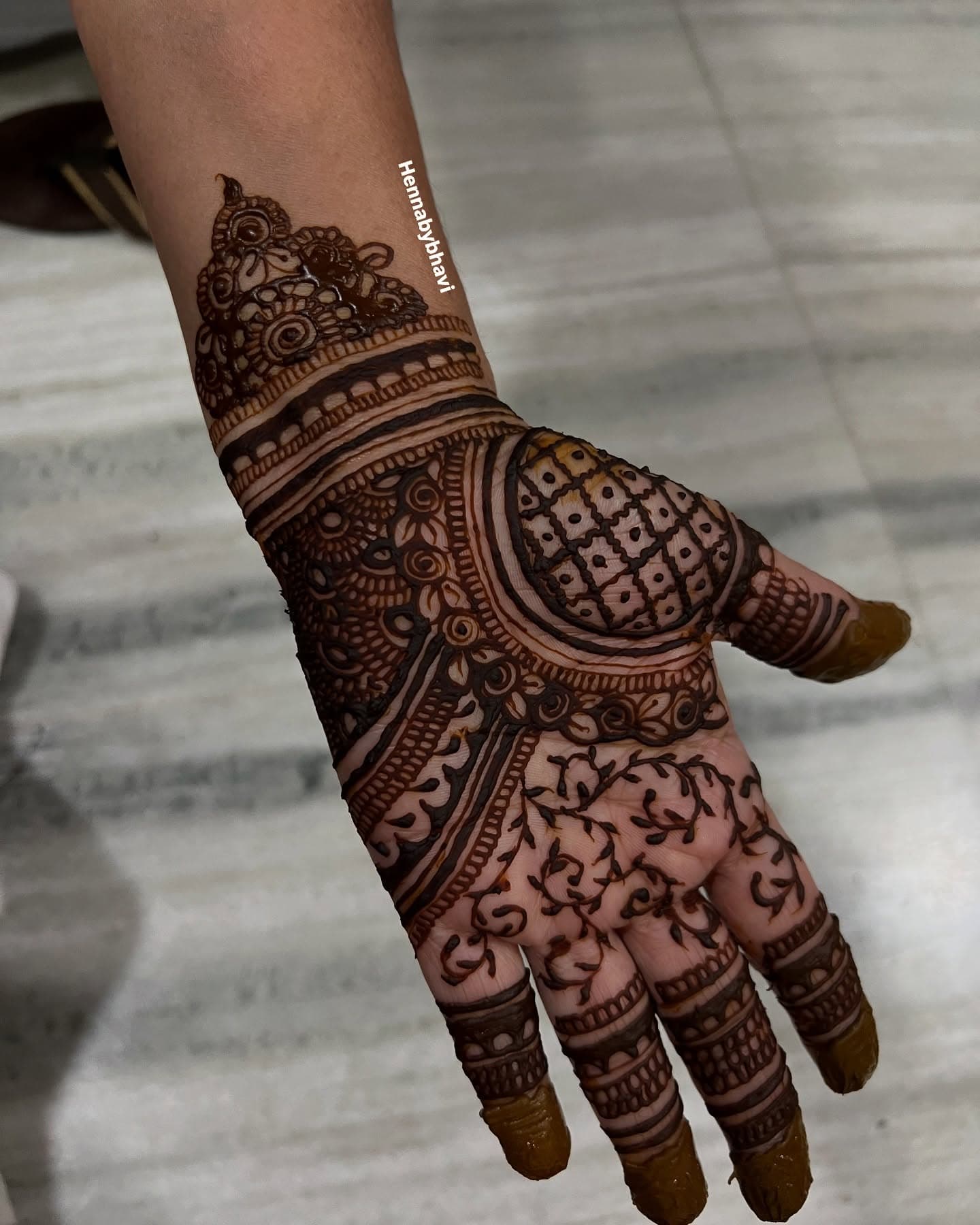 The back of a hand covered in a dense bridal cuff with solid fingertips