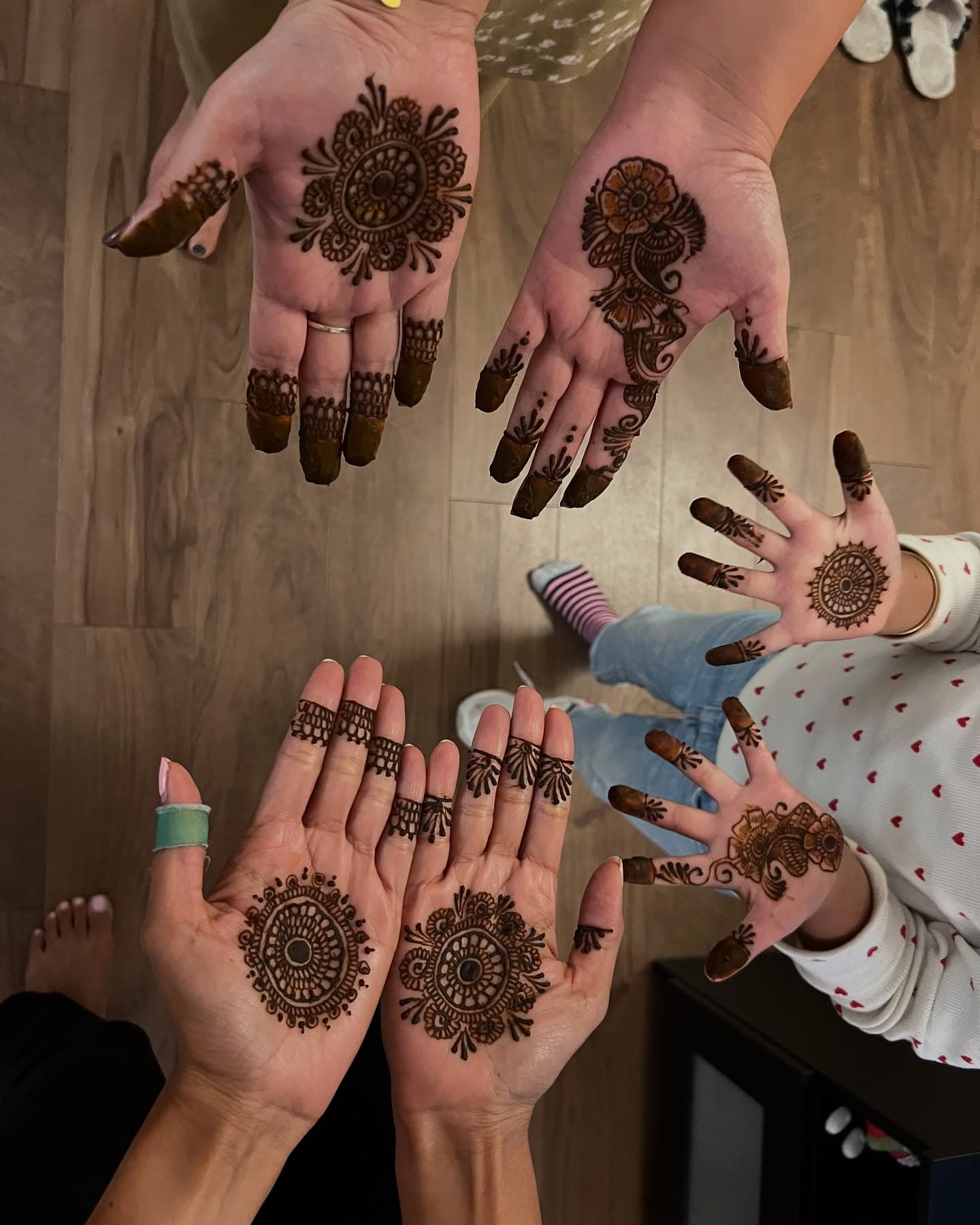 Several hands held out together after a henna party, including a child's